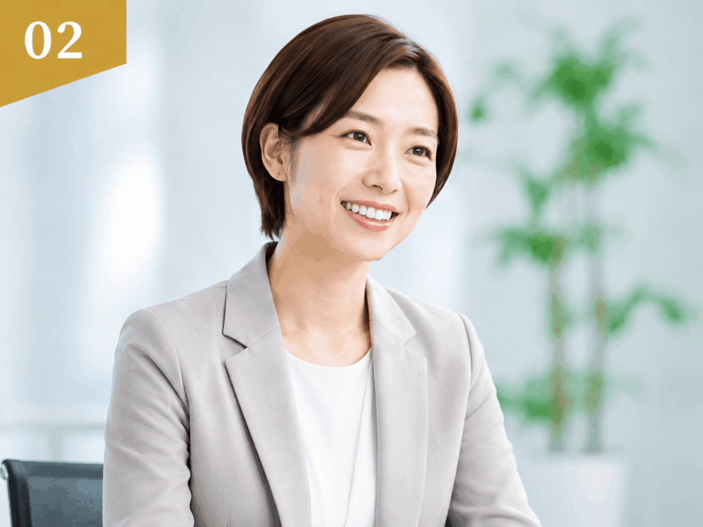明るいオフィスで微笑む女性ビジネスパーソン。左上に02のゴールドバナー付き。